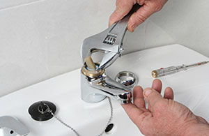 Person fixing bathroom faucet