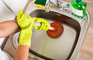 Person unclogging sink